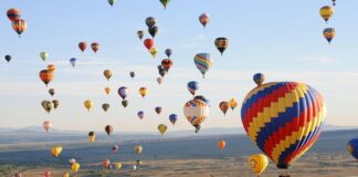 Balon ve hava sporları festivalleri, doğanın güzelliğiyle adrenalin tutkusunu bir araya getirerek ziyaretçilerine unutulmaz anlar yaşatıyor. Türkiye başta olmak üzere dünyanın birçok ülkesinde düzenlenen bu festivaller, hem yerli hem de yabancı turistlerin ilgisini çekiyor. Gökyüzüne yükselen renkli balonlar, yamaç paraşütü şovları ve çeşitli hava sporları etkinlikleri, sadece sporseverleri değil, doğa ve kültür meraklılarını da kendine çekiyor. Konulu bir haber görseli.