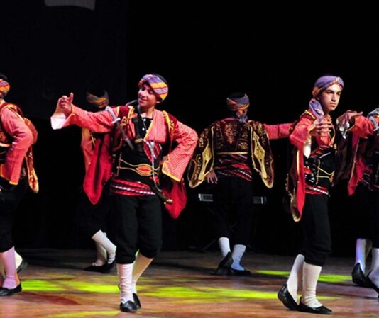 Ritimle Buluşmanın En Canlı Yolu: Dans Festivalleri Dans festivalleri, her yıl dünyanın dört bir yanında binlerce insanı bir araya getiren, enerjisi yüksek ve kültürel anlamda zengin etkinlikler arasında yer alır. Bu festivaller yalnızca dans etmeyi sevenleri değil; aynı zamanda kültürel çeşitliliği, yaratıcılığı ve toplumsal etkileşimi önemseyen herkesi cezbetmektedir. Farklı türlerde dansların sahnelendiği, yerel ve uluslararası grupların performanslar sergilediği bu organizasyonlar; sanat, spor ve eğlencenin buluştuğu alanlar olarak dikkat çeker. Konulu bir haber görseli.