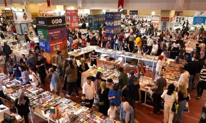 Kitap ve Kütüphane Festivalleri Kültürel Hafızanın Kutlandığı Etkinlikler Kitap ve kütüphane festivalleri, son yıllarda hem entelektüel gelişimi destekleyen hem de kültürel mirasın yaşatılmasına katkı sunan önemli organizasyonlar hâline gelmiştir. Özellikle dijitalleşmenin hız kazandığı bir çağda, kitapla ve bilgiyle kurulan temasın farklı bir düzleme taşındığı bu festivaller, okurların yanı sıra yazarlar, yayıncılar, akademisyenler ve kütüphanecileri bir araya getirmektedir. Bu tür etkinlikler, sadece kitaplara olan ilgiyi artırmakla kalmaz, aynı zamanda kütüphanelerin de sosyal ve kültürel hayattaki rolünü yeniden hatırlatır. Konulu bir haber görseli.